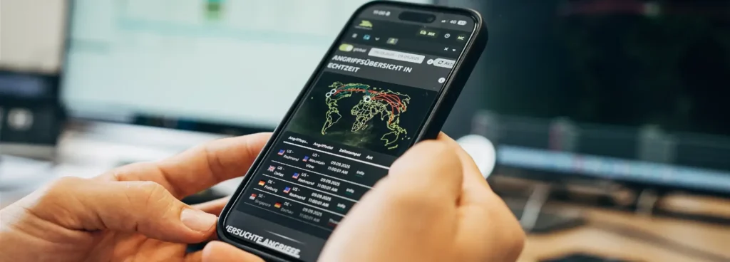Zwei Hände halten ein Smartphone auf dem zum Thema IT-Security eine Statistik über Cyberangriffe aufgerufen ist.