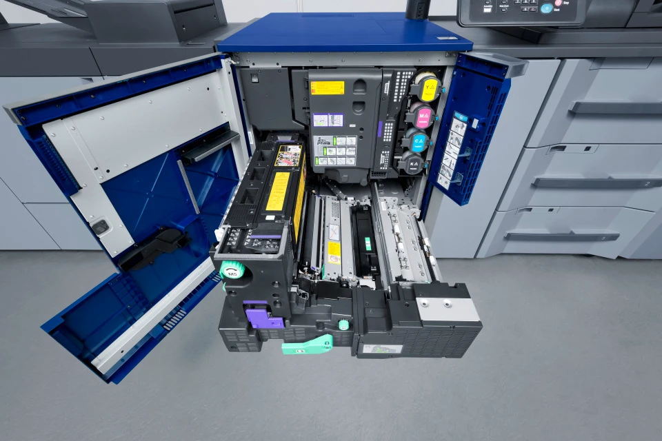 Geöffnetes Druckwerk eines Konica Minolta AccurioPress C7100 – Blick auf CMYK-Tonereinheiten, Druckwalzen und Mechanik eines Hochleistungs-Farbproduktionsdruckers