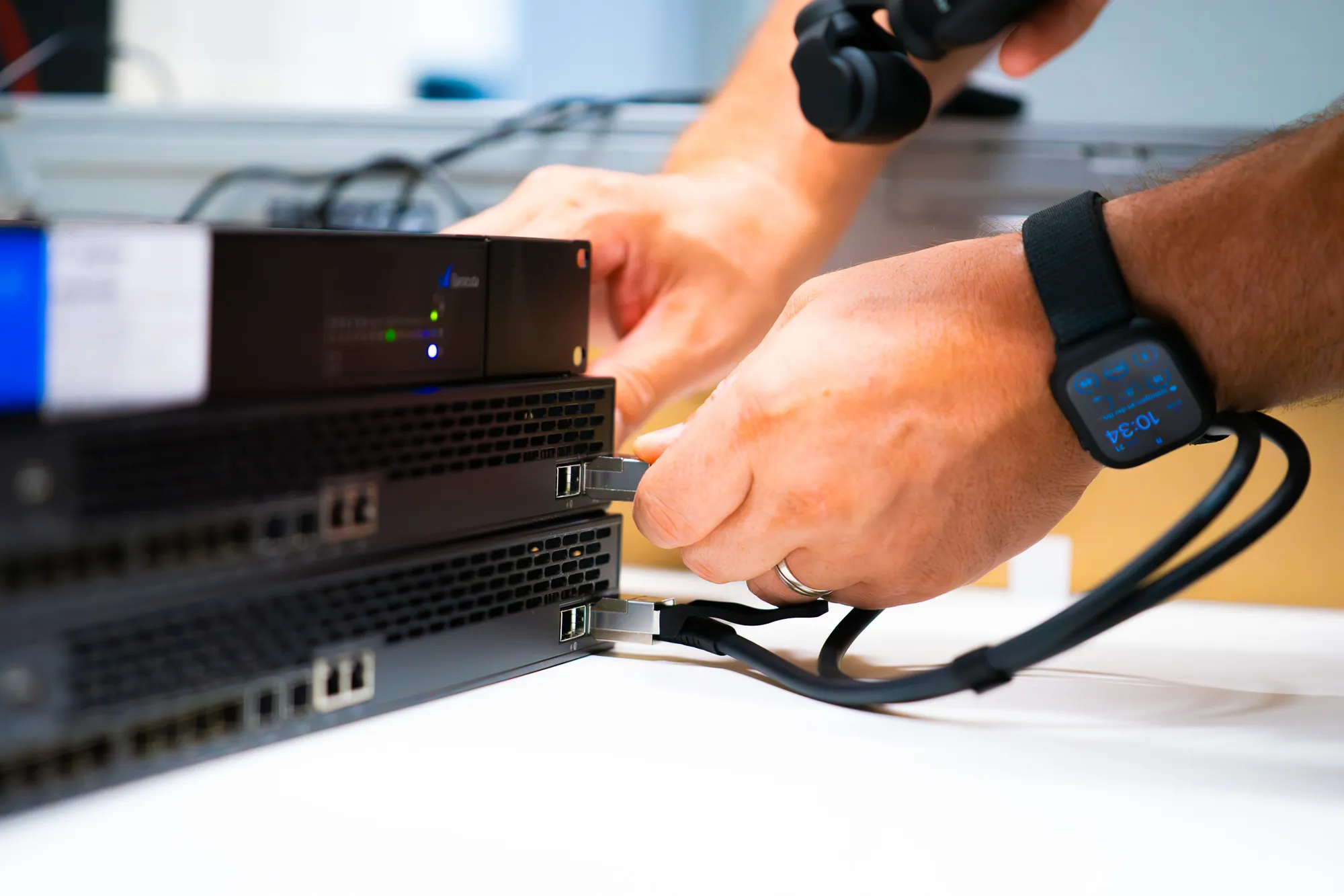 Allen IT Anforderungen gewachsen: Switch auf Microsoft 365 und Windows 11 Upgrade 2 Techniker zieht ein Netzwerkkabel aus dem Switch im Serverschrank.
