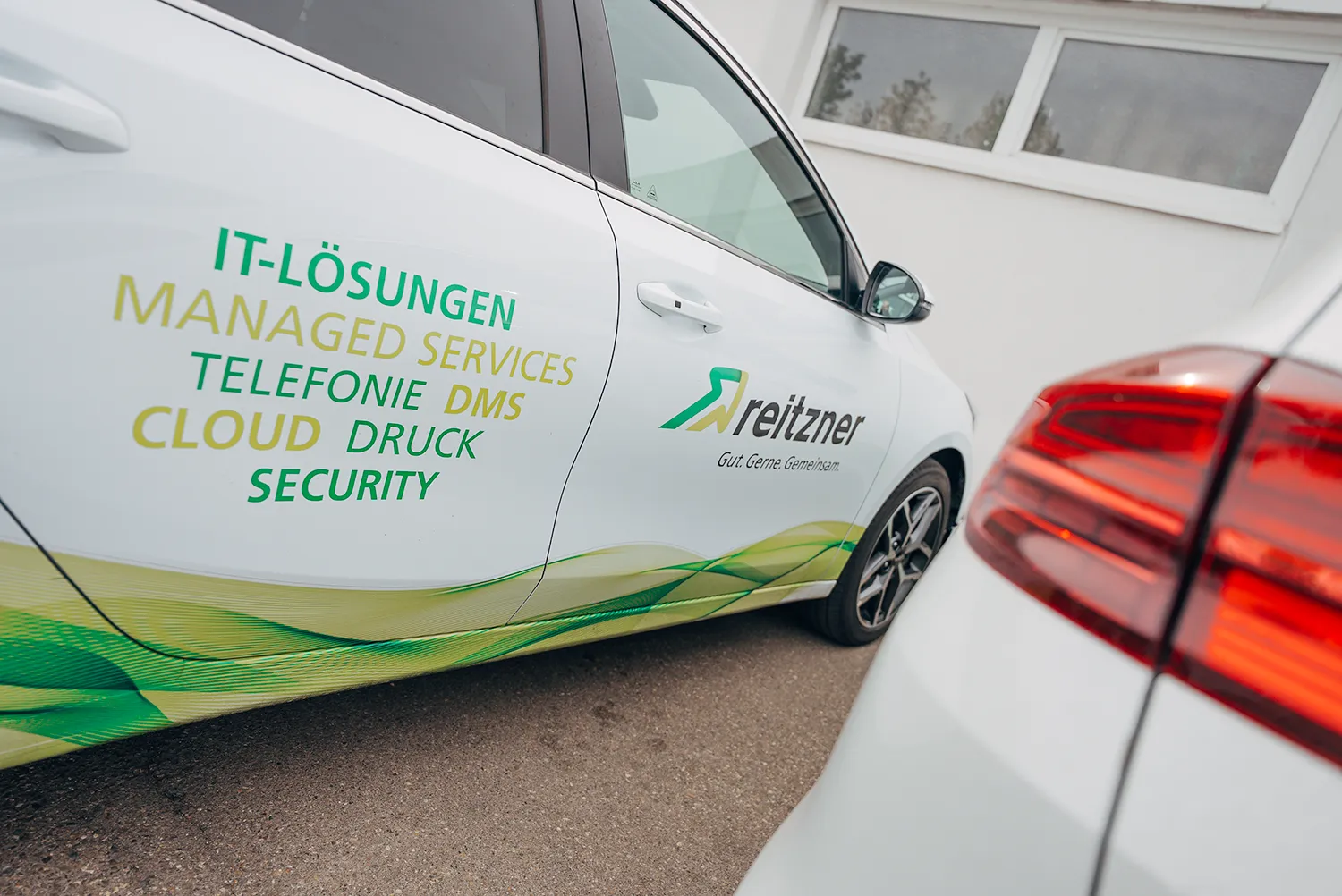 Beschriftetes Servicefahrzeug der reitzner AG mit den Leistungen IT-Lösungen, Managed Services, Telefonie, DMS, Cloud, Druck und Security